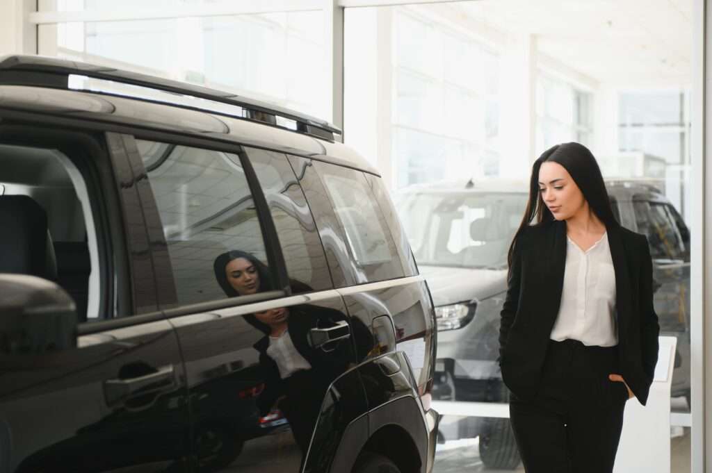 businesswoman-choosing-new-car-at-dealership-show